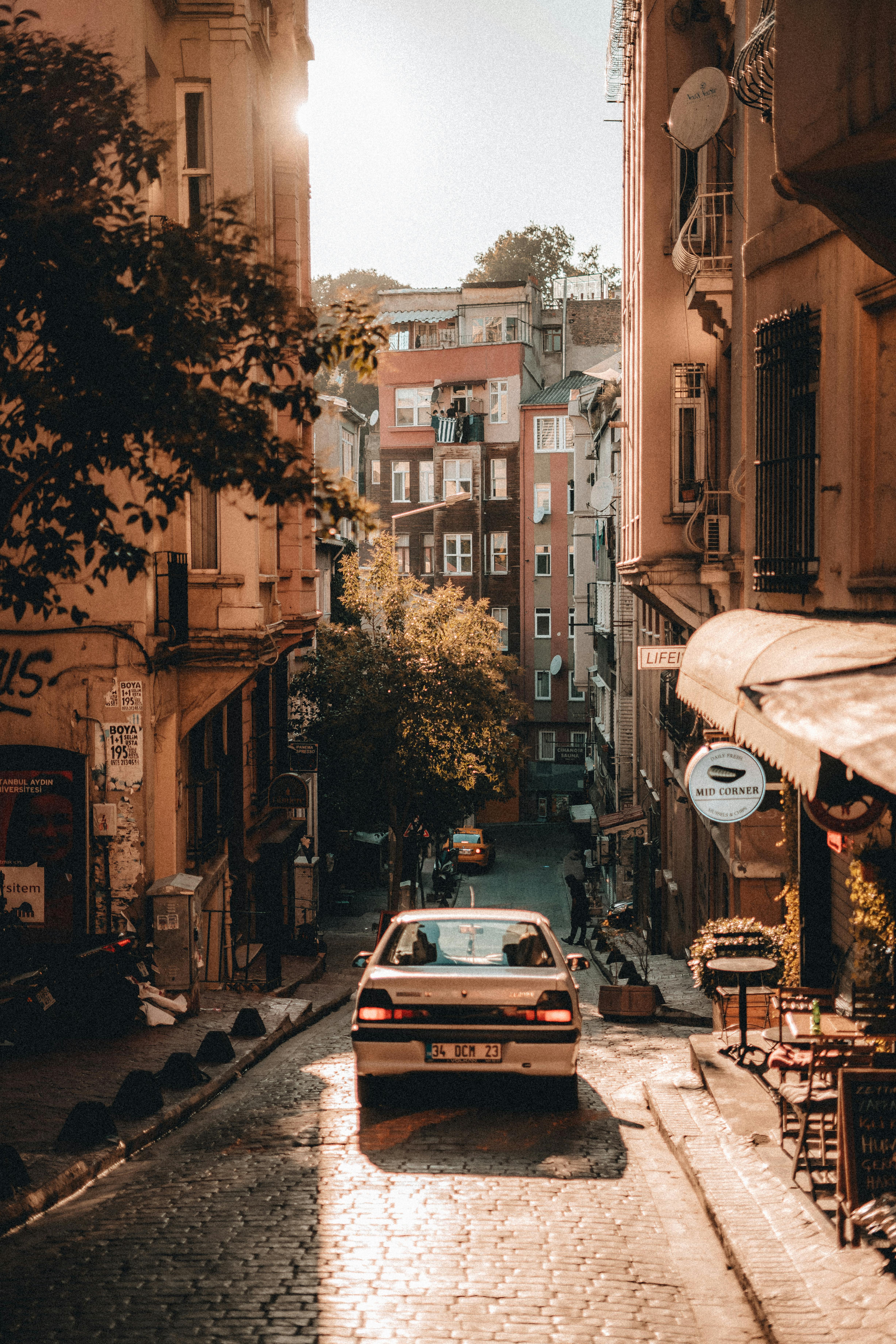 道路でカメラストラップを使い風景の光を捉える写真家