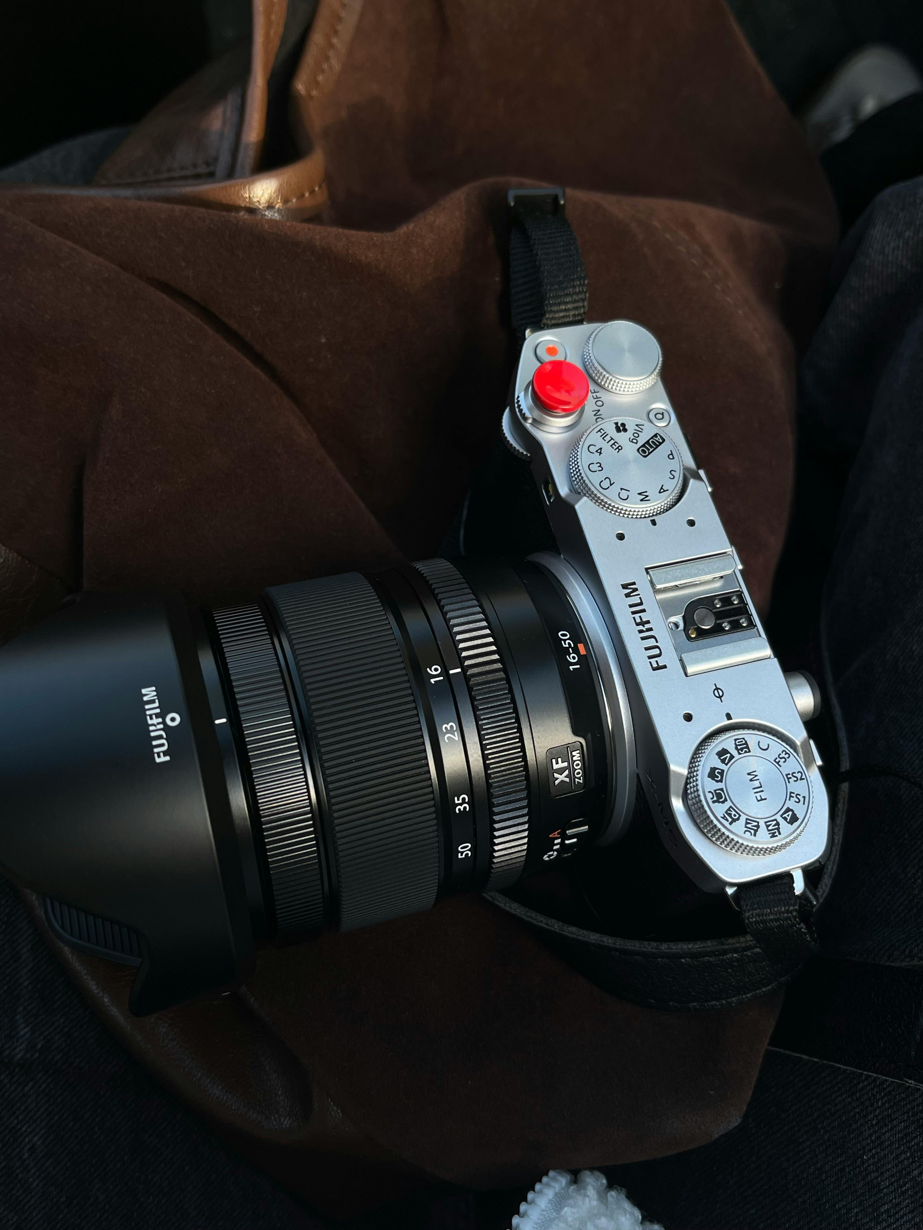 Minimal camera kit laid out on a wooden surface with a backpack ready for hiking