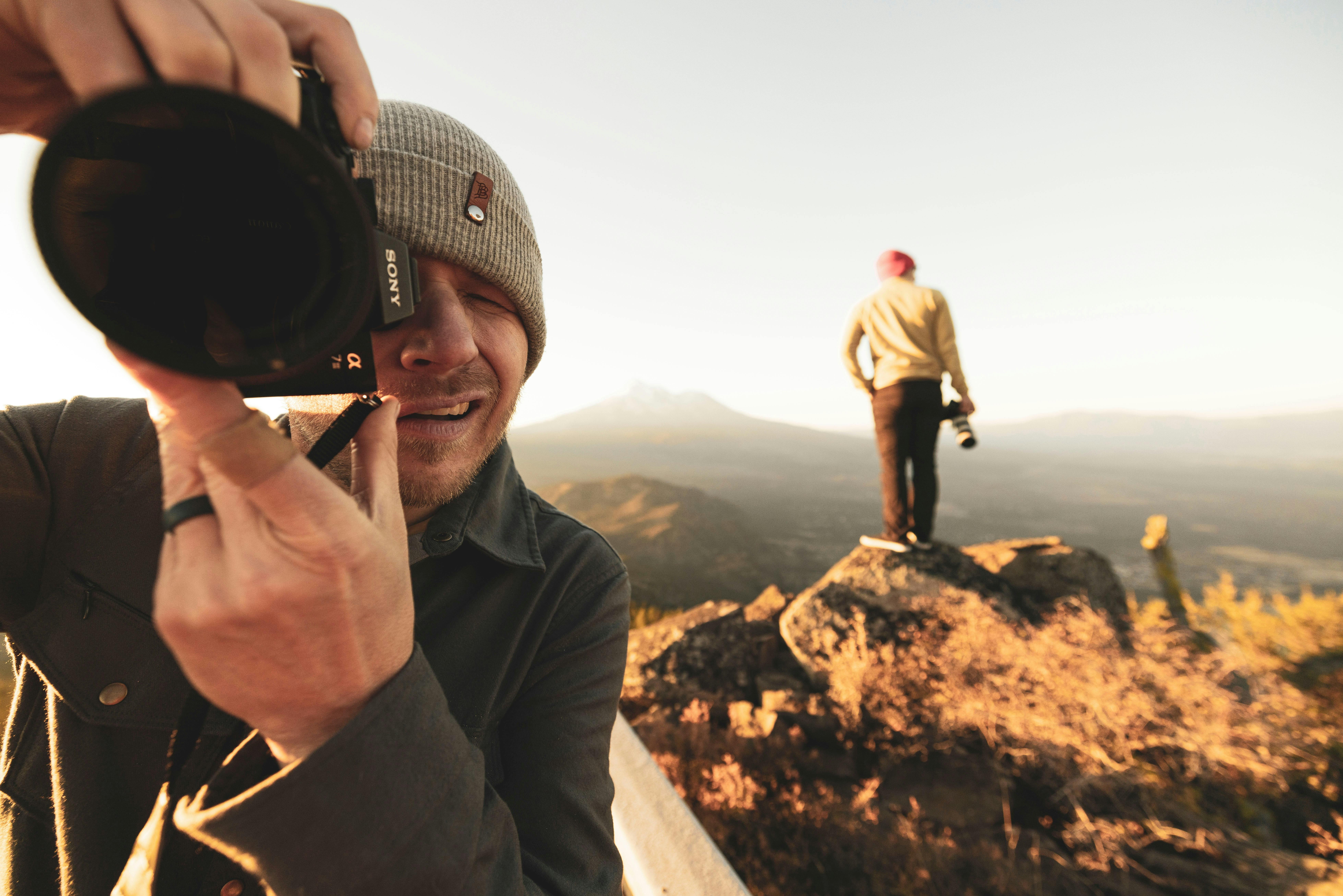 Modern mirrorless camera body on a rock with mountains in the background