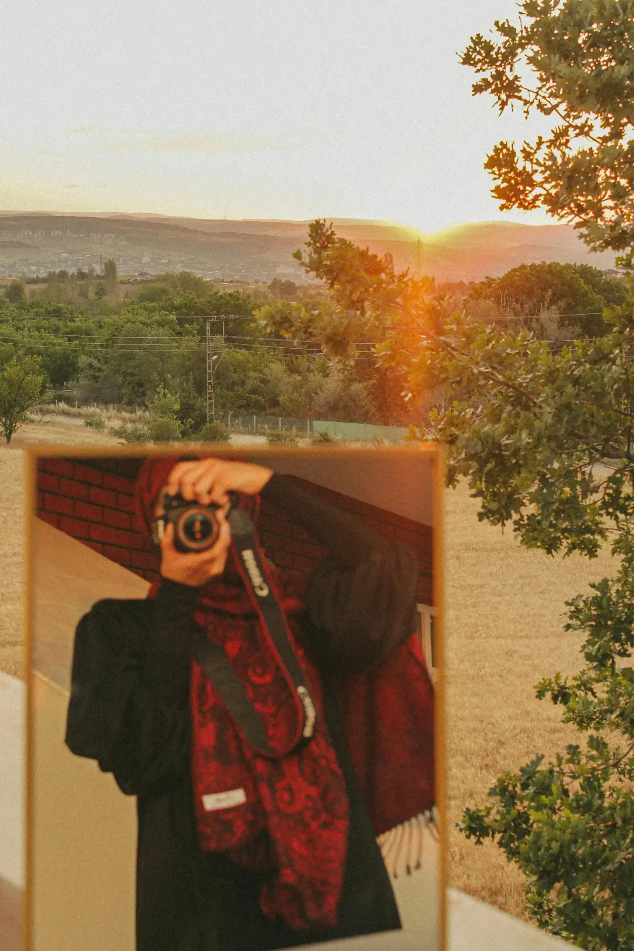 崖の上で旅行撮影の準備をする写真家