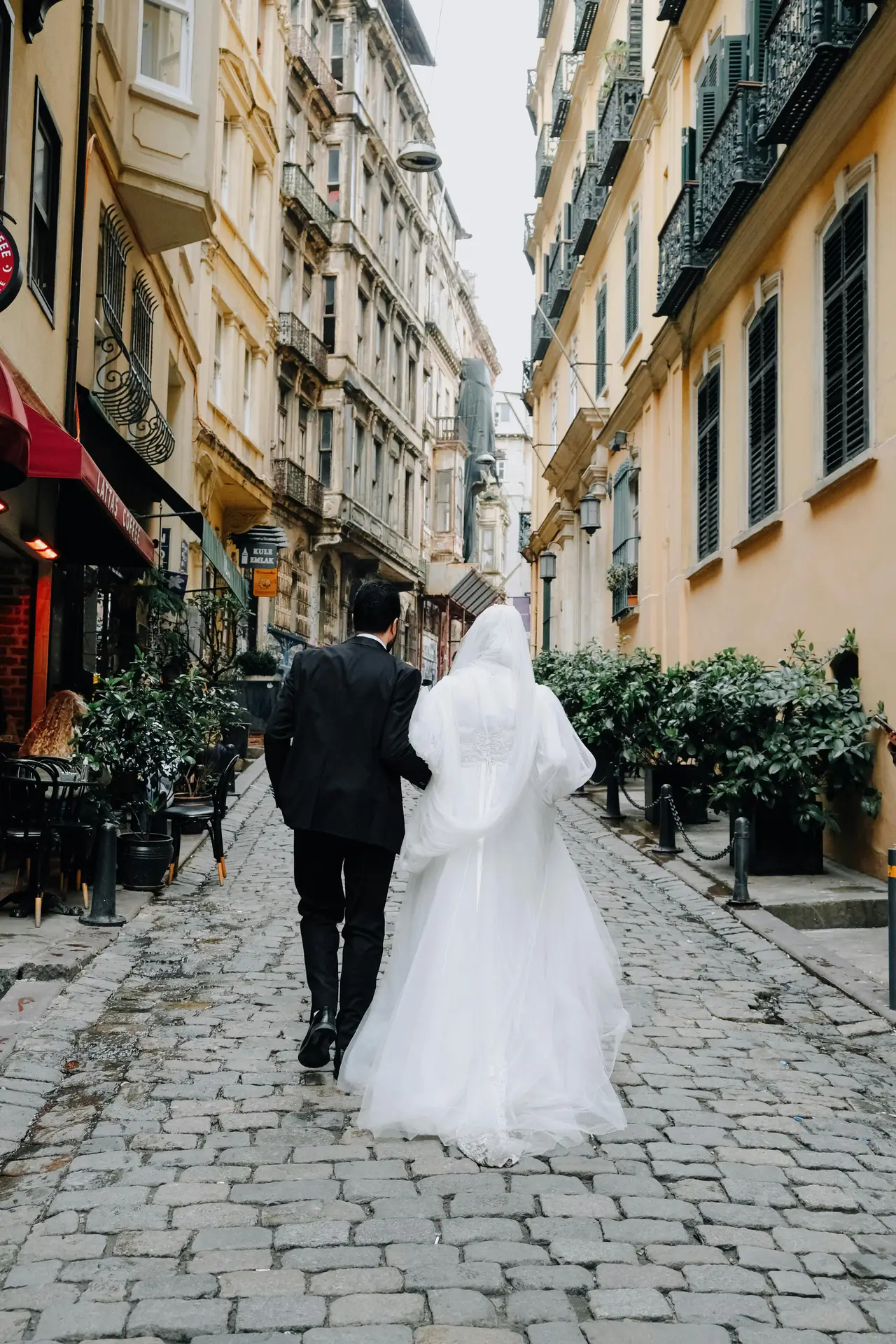 Stel loopt over een stadsstraat, een natuurlijk licht bruiloftsmoment