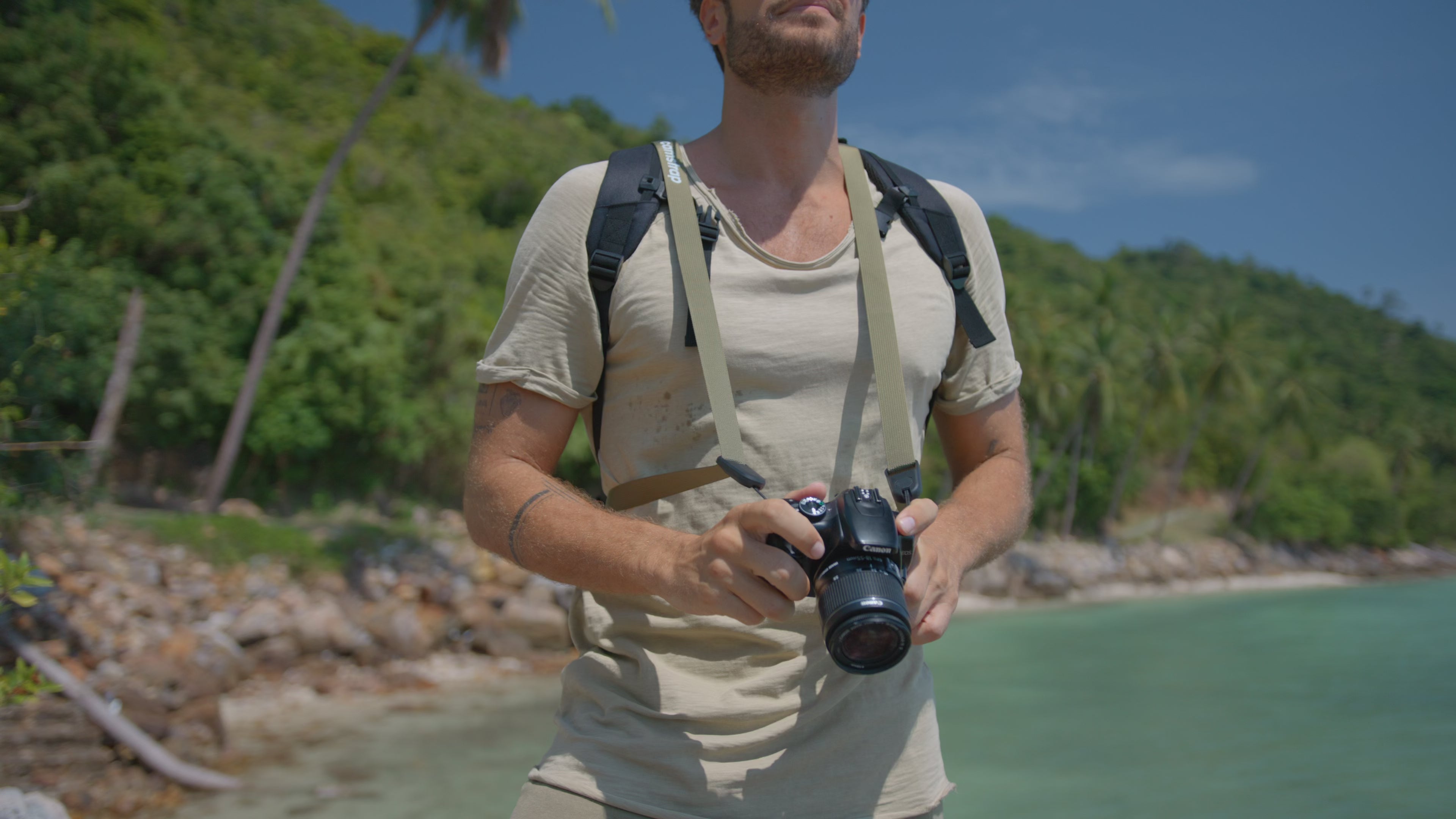 Camstrap Explorer being used by a hiker photographing mountain scenery