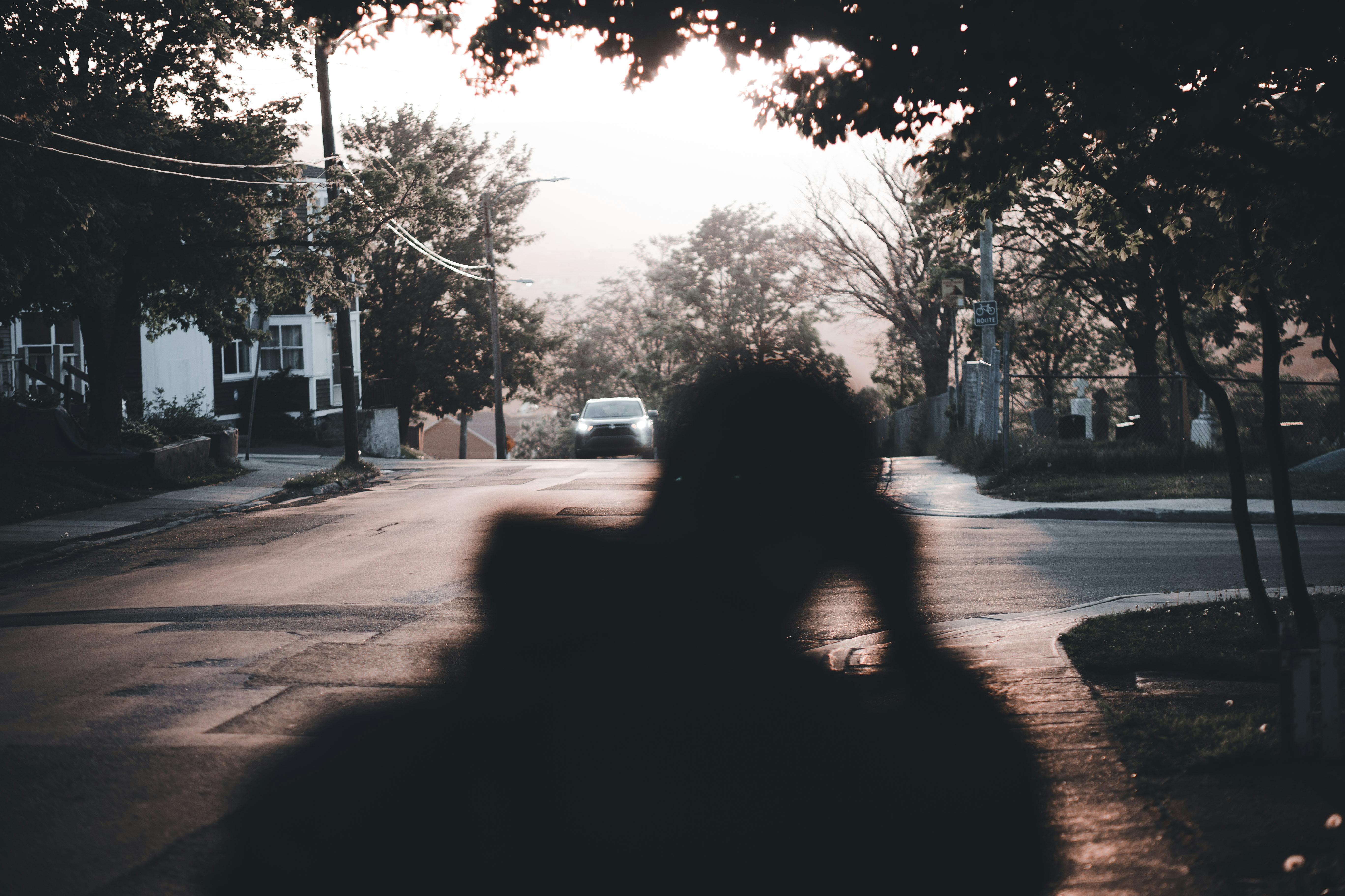 Photographer walking through a city street with a small camera ready for candid shots